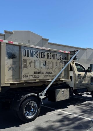 HaulNJunk dumpster truck delivering to a job site